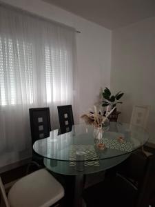 a dining room with a glass table and chairs at Studio apartman Delic in Podgorica