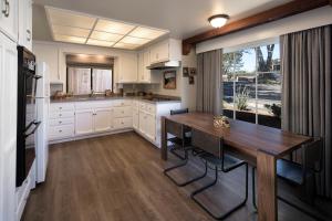 a kitchen with a wooden table and a large window at Oceanpoint Ranch in Cambria