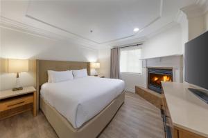 a bedroom with a bed and a fireplace at Pelican Inn & Suites in Cambria