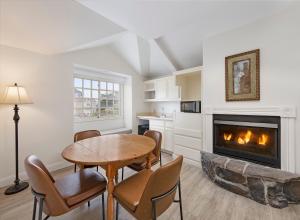 a living room with a table and a fireplace at Pelican Inn & Suites in Cambria