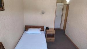 a small bedroom with a bed and a small cabinet at Comfort Continent in Oktyabrʼ