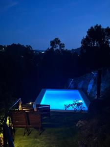 a swimming pool in the yard at night at Pedra Douro in Fontelas
