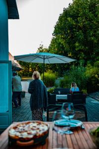 a woman standing in front of a table with an umbrella at Pärla in Kåseberga in Löderup