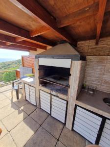 a outdoor kitchen with a grill on a patio at Portezuelo in Zapallar