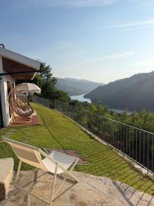 a chair and an umbrella on a balcony with a view at Miradouro 13 - Gerês in Geres