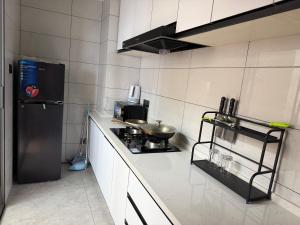a small kitchen with a stove and a refrigerator at Chouke Maison in Abidjan