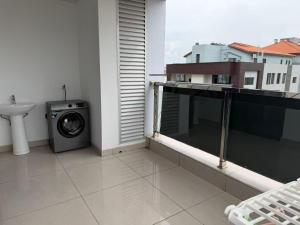 a bathroom with a washing machine on a balcony at Chouke Maison in Abidjan