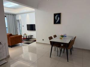a dining room and living room with a table and chairs at Chouke Maison in Abidjan