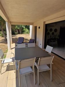 a table and chairs on a porch with a table and chairs at Résidence Les Jardins du Piale in Bonifacio +4 photos