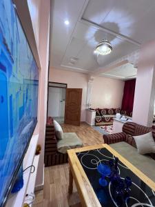 a living room with a large tv and a couch at velaris in Chefchaouen