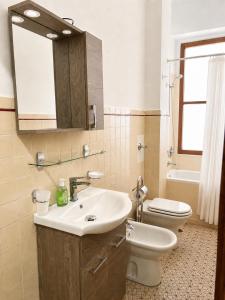 a bathroom with a sink and a toilet and a mirror at Savona Casa Dolce Vita in Savona
