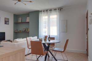 a living room with a table and a couch at Villemur Cosy in Villemur-sur-Tarn
