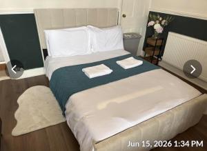 a bedroom with a large bed with two towels on it at Luxurious Modern Town House in Gillingham