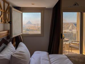a room with a couch and a window with a view at Grand Museum with Pyramids view inn in Cairo