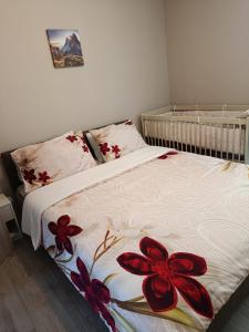 a bedroom with a bed with red flowers on it at Ferienwohnung Anna Gerolstein in Gerolstein
