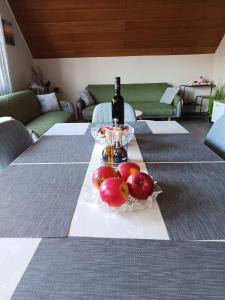 a table with a bottle of wine and apples on it at Ferienwohnung Anna Gerolstein in Gerolstein +10 photos