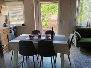 a dining room table with chairs and a bottle of wine at Ferienwohnung Anna Gerolstein in Gerolstein