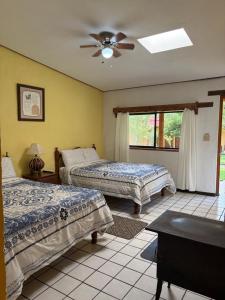 a bedroom with two beds and a ceiling fan at Hotel Paraiso del Oso in Cerocahui