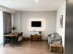 a living room with a table and a chair at Batumi - Seaside Stunning Apartment in Batumi