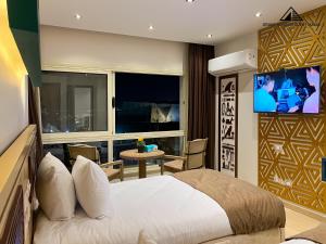 a bedroom with a bed and a tv and a table at Grand Museum with Pyramids view inn in Cairo