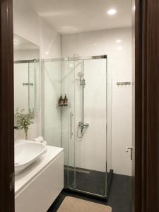 a bathroom with a glass shower and a sink at Batumi - Seaside Stunning Apartment in Batumi
