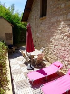 a patio with a table and chairs and an umbrella at La Maison d Ingrandes - relais Valami in Ingrandes-de-Touraine