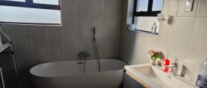 a bathroom with a bath tub and a sink at Naomy's Place in Harare