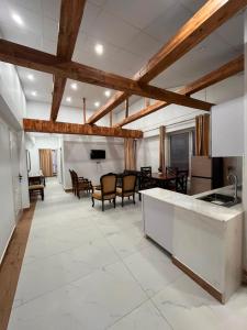 a large room with a kitchen and a living room at Pine Cottage in Murree