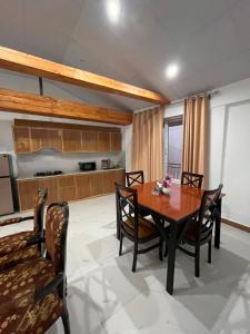 a dining room with a wooden table and chairs at Pine Cottage in Murree +8 photos