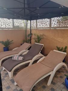a group of four beds sitting under an umbrella at Dar Diaft'na in Marrakesh
