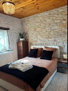 a bedroom with a large bed with a stone wall at Hélios ranch in Varennes-le-Grand