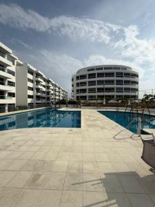 a building with a swimming pool in front of a building at Sensacional Apartamento Serena del Mar in Serena del Mar