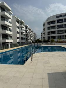 a swimming pool in front of two apartment buildings at Sensacional Apartamento Serena del Mar in Serena del Mar +5 photos