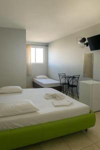 a bedroom with a bed and a table and chairs at Londres hotel thur in Brasília