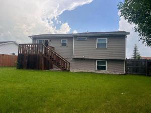 a house with a wooden deck in a yard at Cozy house in Moorhead