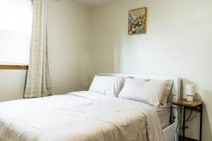 a bedroom with a white bed with a window at Cozy house in Moorhead