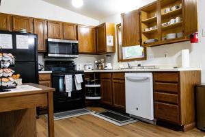 a kitchen with wooden cabinets and black appliances at Cozy house in Moorhead