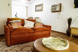 a living room with a brown couch and a table at Cozy house in Moorhead