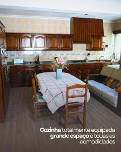 a kitchen with a table with chairs and a couch at Vivenda Varandas in Lagoaça