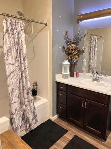 a bathroom with a sink and a shower curtain at Union at the loop in Lawrence