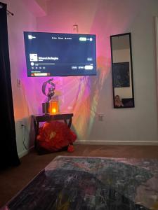 a living room with a large tv on the wall at Union at the loop in Lawrence