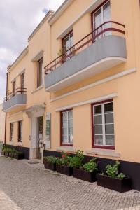 a building with balconies and plants on a street at Most Art Boutique Hostel in Leiria