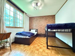 a bedroom with two bunk beds and a brick wall at Guest house AZSINN in Ueda +7 photos