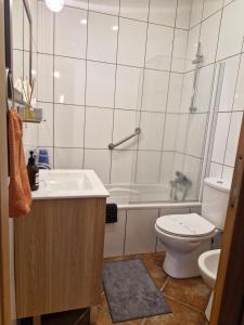 a bathroom with a tub and a toilet and a sink at Apartamento das Fontes in Furnas +9 photos