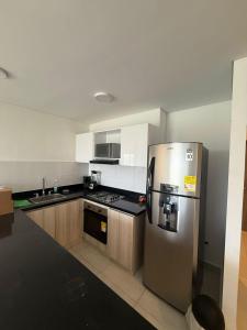 a kitchen with a stainless steel refrigerator and cabinets at Sensacional Apartamento Serena del Mar in Serena del Mar