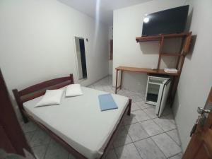 a small bedroom with a bed and a flat screen tv at Hotel Amaro in Luis Correia