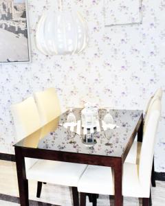 a dining room with a table and white chairs at Leader Hotels Salmiya in Kuwait