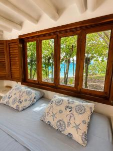 a bed with two pillows in a room with windows at Isla Risa in Cartagena de Indias