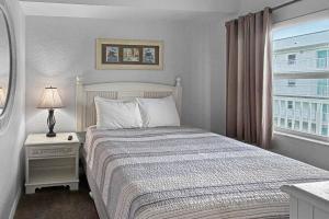 a white bedroom with a bed and a window at 501-S - Sunset Vistas in St. Pete Beach