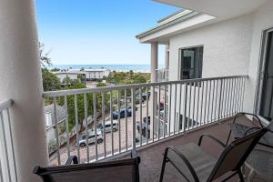 a balcony with chairs and a view of a parking lot at 501-S - Sunset Vistas in St. Pete Beach